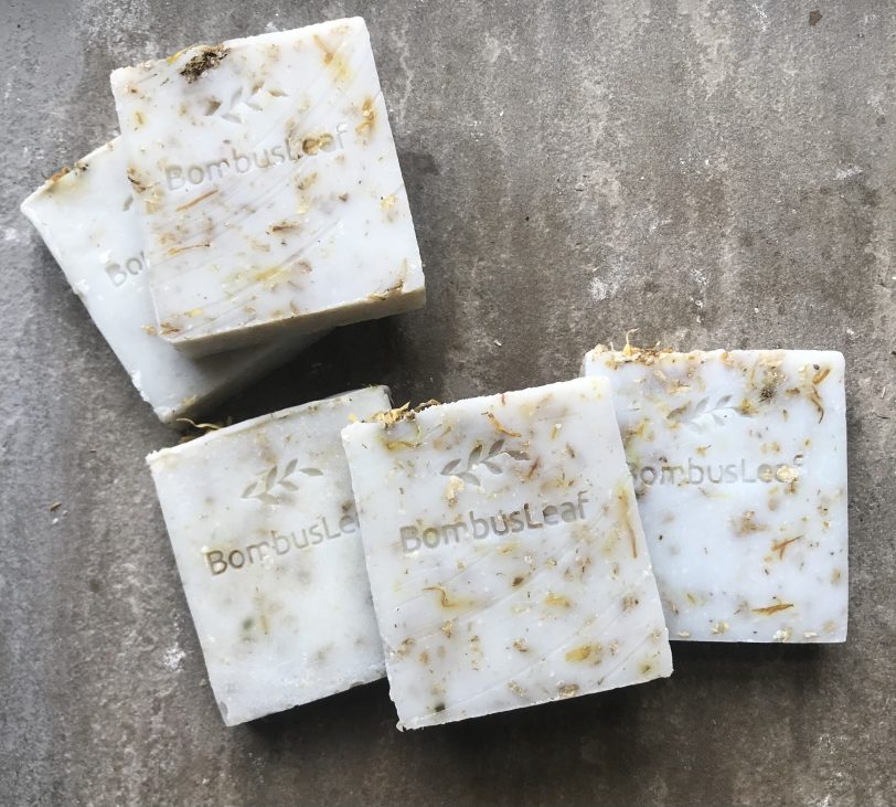 Oat, Chamomile & Calendula Hand & Body Soap Scrub Stacked on a Stone shelf